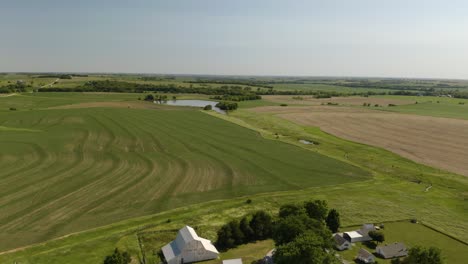 Aerial-Pullback-Reveals-Farm-House-on-Large-Fields-of-Farmland-in-Rural-United-States
