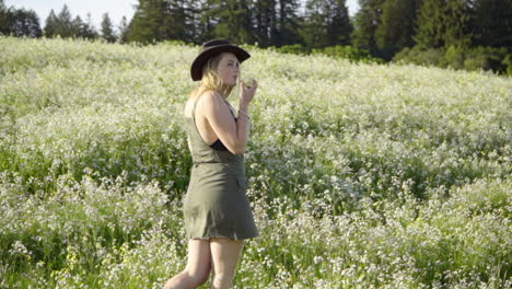 slomo de mujer joven comiendo una manzana en un campo de flores