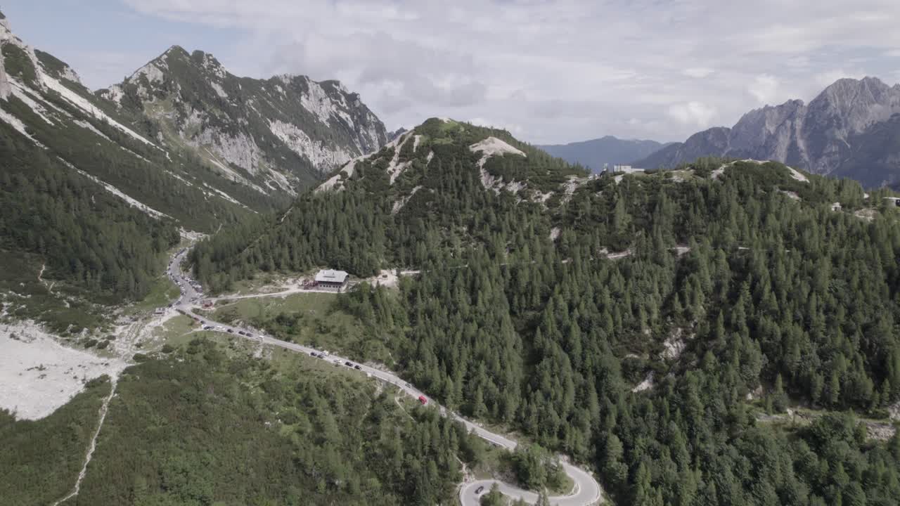 video de drones con toma frontal descriptiva sobre el paso vrsc en eslovenia con montañas en el horizonte