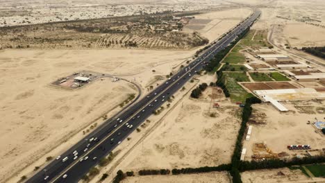 Highway-in-Kuwait-desert-landscape,-cars-driving