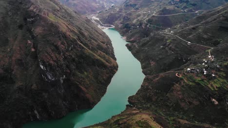 aerial pan up view of river at ha giang through valley in vietnam. follow shot
