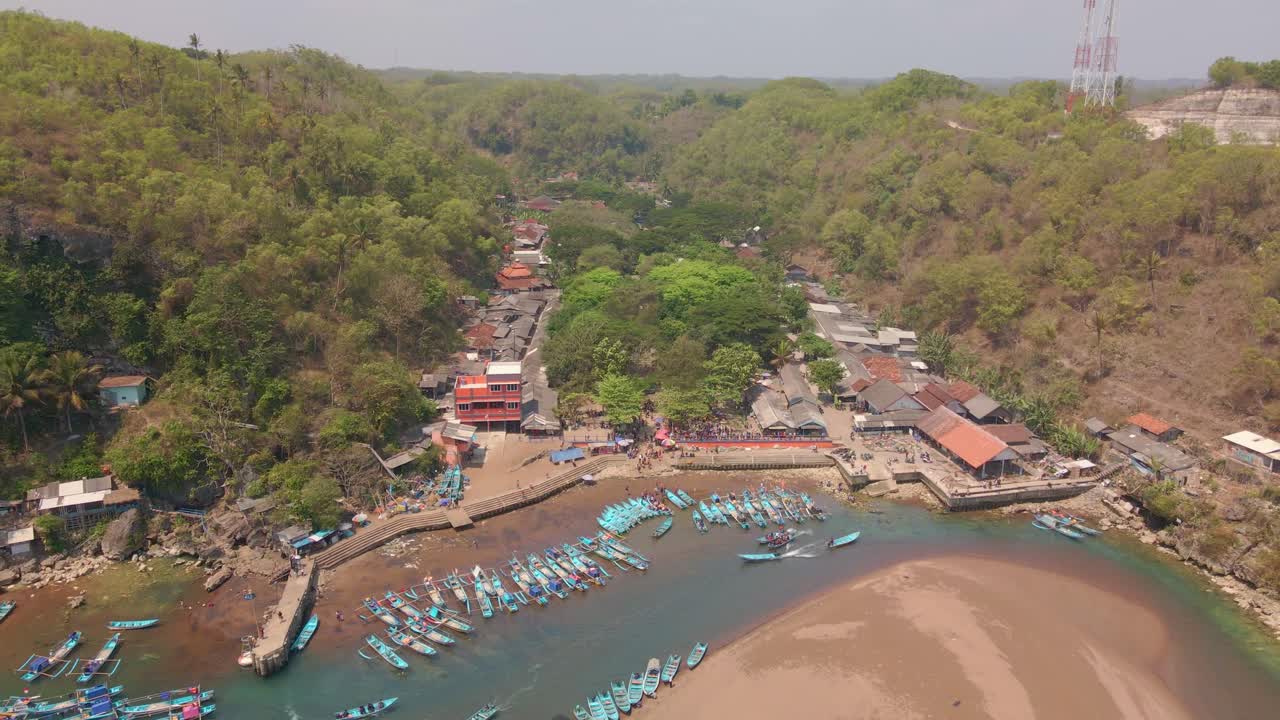Veduta aerea del pittoresco villaggio di pescatori indonesiano di Baron Beach di giorno, ripresa in allontanamento