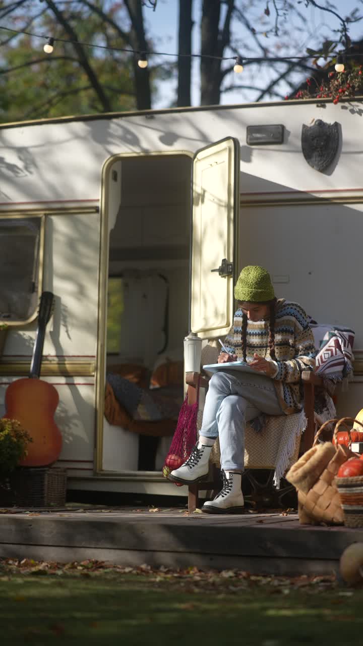 가을에 캠퍼밴에서 그림을 그리는 여자