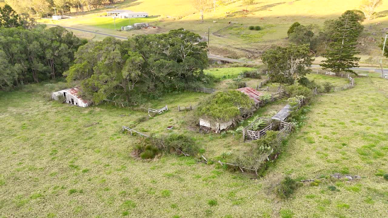 Drone footage of a deserted farm house in Australia with overgrown trees and vegetation