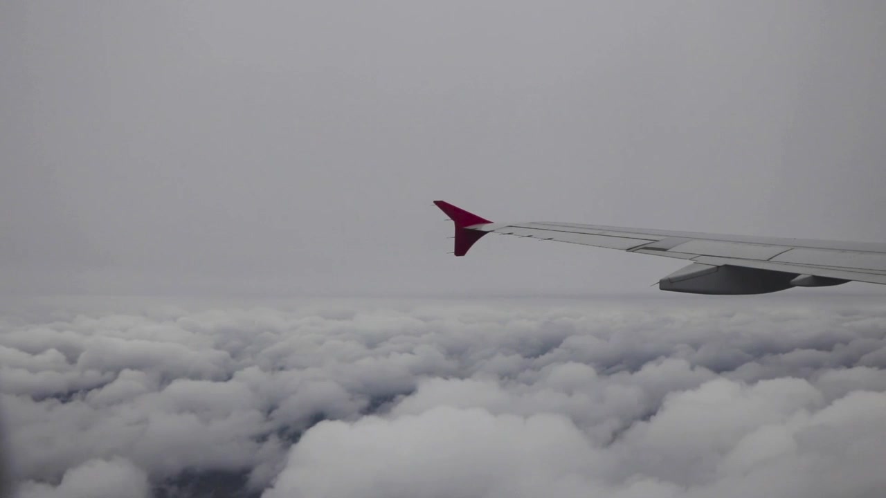 Vue d'une aile d'avion volant au-dessus de nuages cotonneux