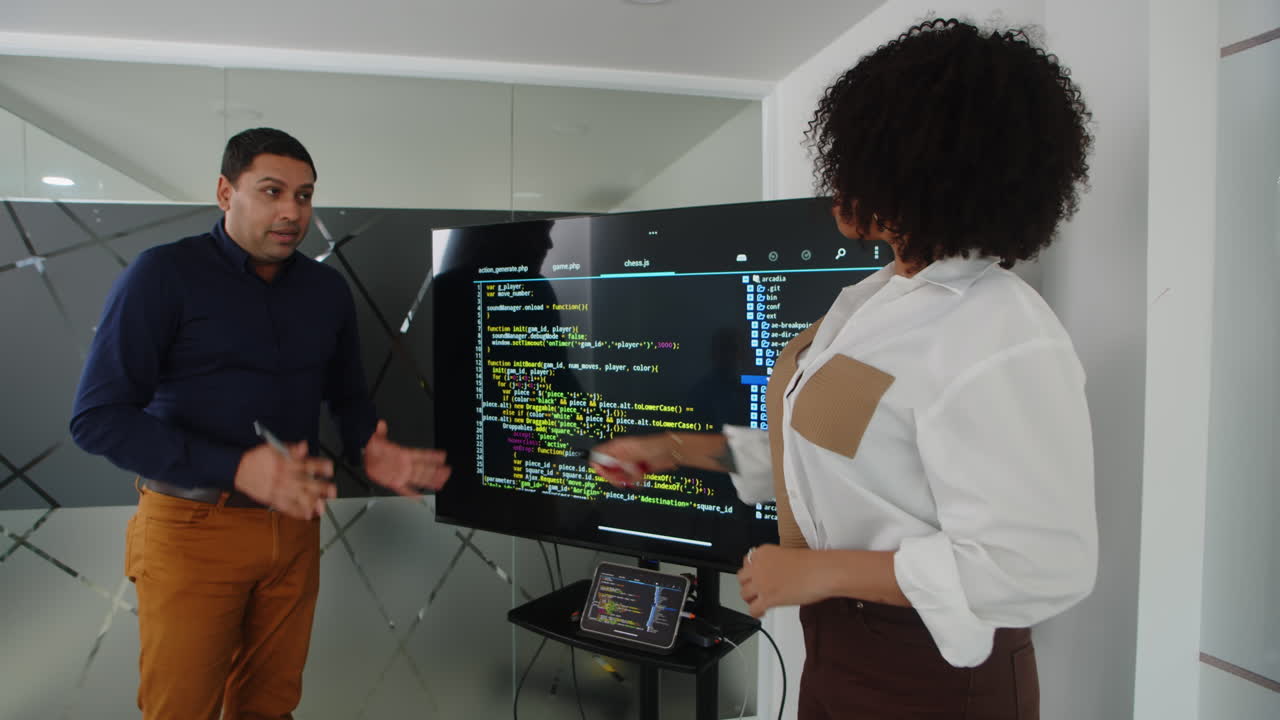 Developer Presenting Script to Manager next to Monitor