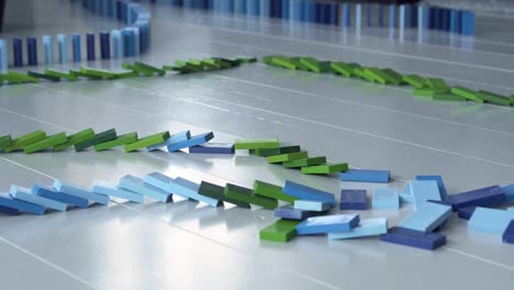larga línea de dominó cayendo, bloques de dominó azules y verdes