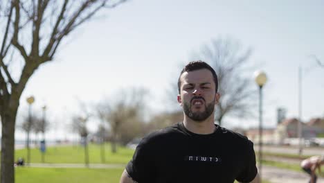 Focused-bearded-sportsman-running-in-park.