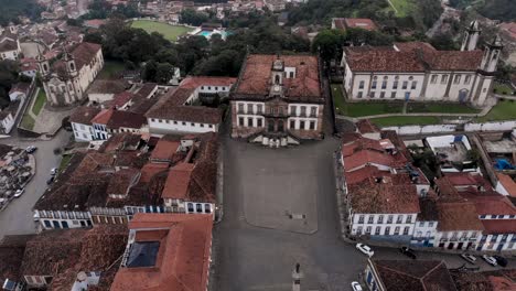 central square of the black gold mining city of ouro preto in minas gerais, with the municipal building flanked by various churches revealing the tiradentes monument in the foreground