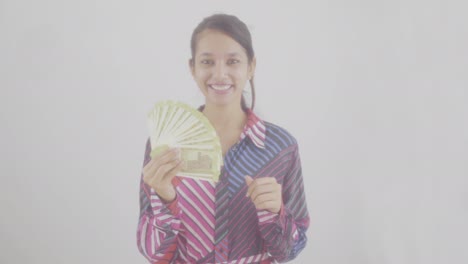 modelo femenina feliz con dinero en efectivo en el estudio