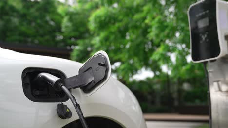 closeup progressive concept of electric car being charged at charging station.