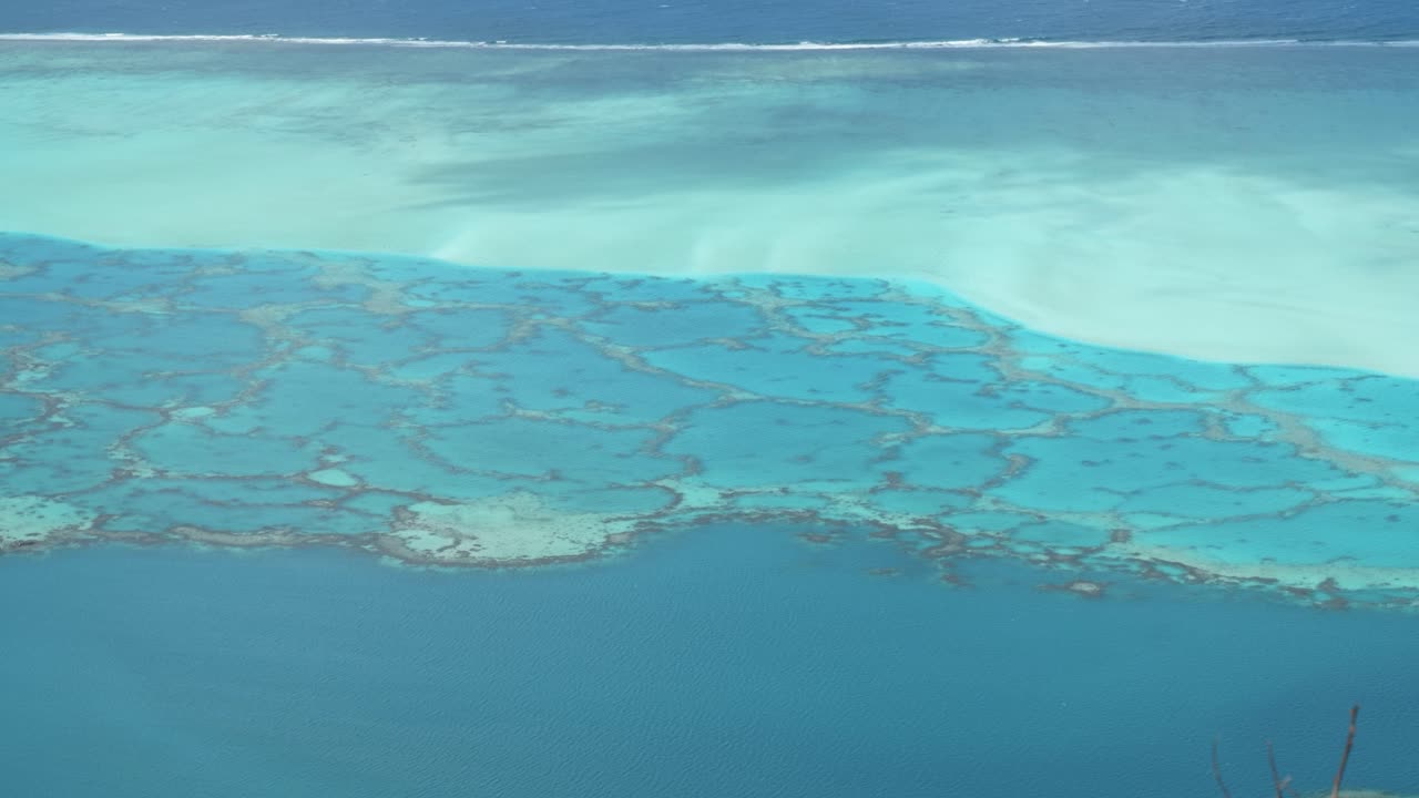 Detail view of lagoon and coral reefs in turquoise shallow water in a pacific tropical island Maupiti, French Polynesia.