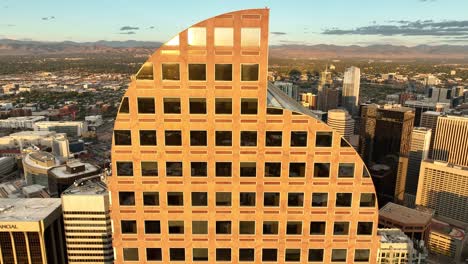 Descenso-Aéreo-Con-Reflejo-Del-Atardecer-En-Las-Ventanas-Del-Centro-De-Wells-Fargo,-Denver