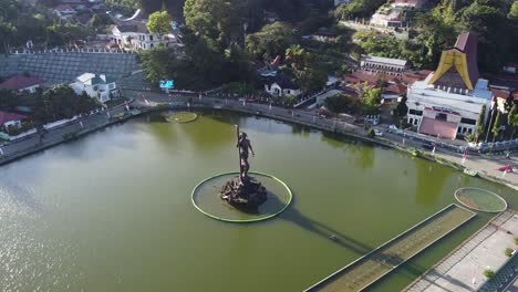 aerial view of a lakeside town with a prominent statue