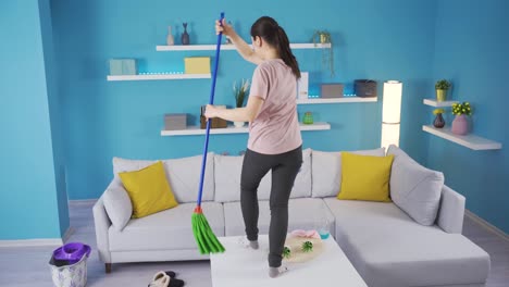 happy asian young woman cleaning house listening music and dancing.