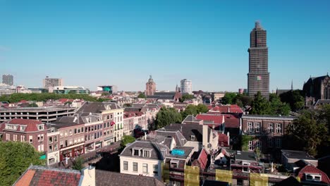 aerial drone downward movement shot over the historic medieval dutch city centre of utrecht with view of cathedral in distance at daytime