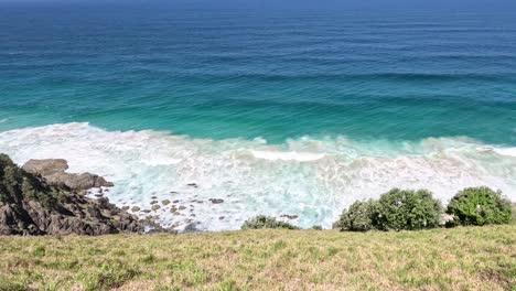 waves crashing on rocky shore with clear skies