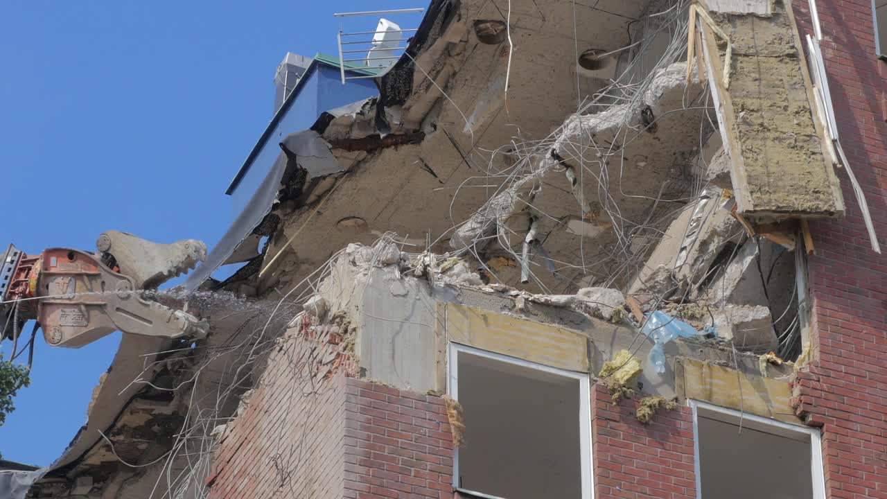 Stockholm, Sweden - 2021.08.13: Demolition of an office building in Stockholm. Heavy machinery can be seen tearing down the interior of the building.