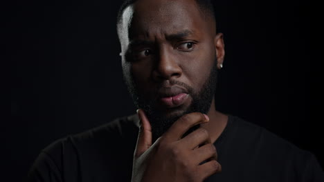 african american man getting an idea indoors. dreamy man posing in studio