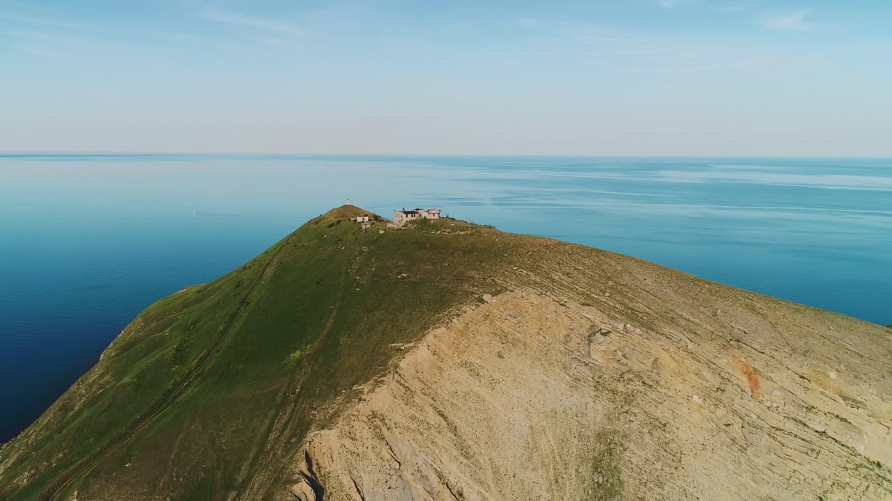 Aerial view of a lighthouse and ruins on a coastal hilltop