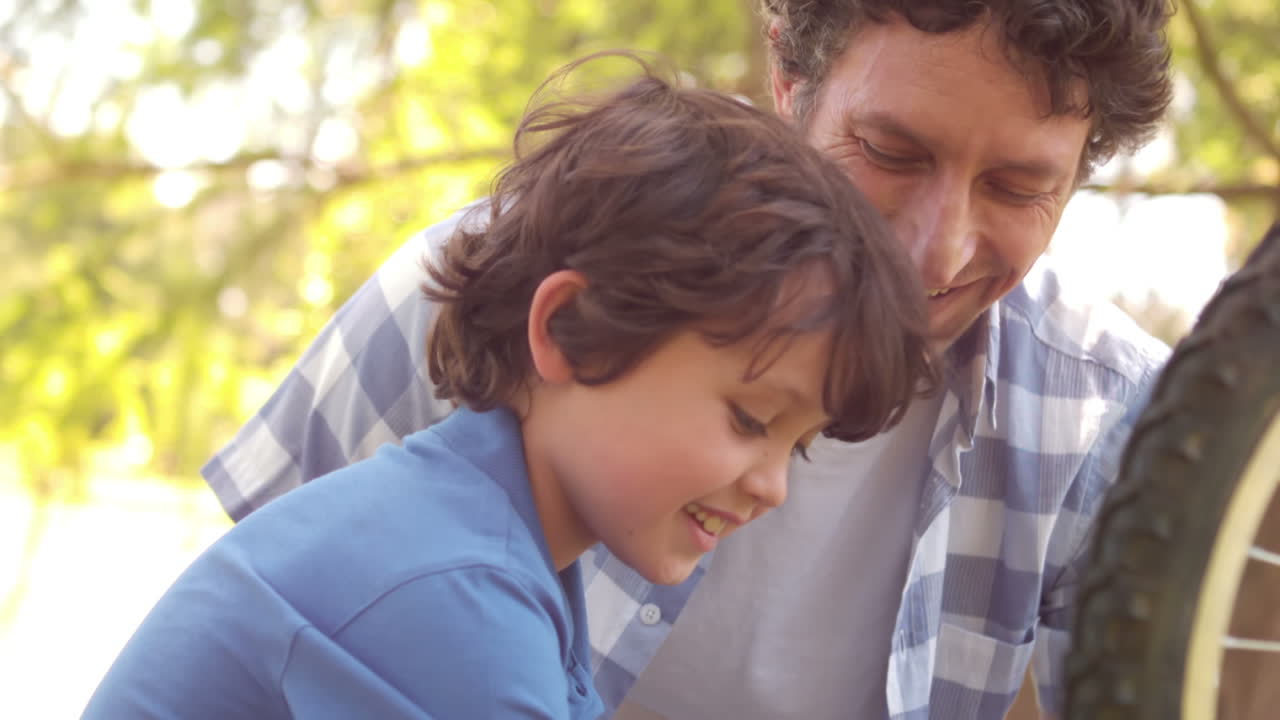 padre e hijo reparando una bicicleta
