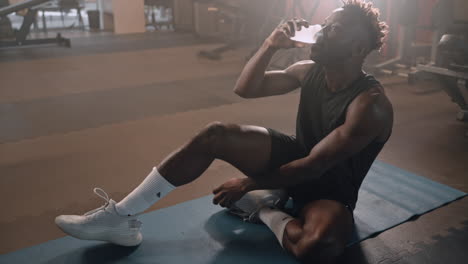 man drinking water after workout