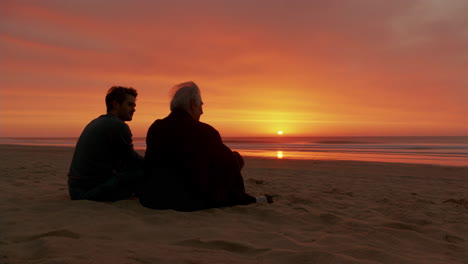 two people watching a sunset on the beach