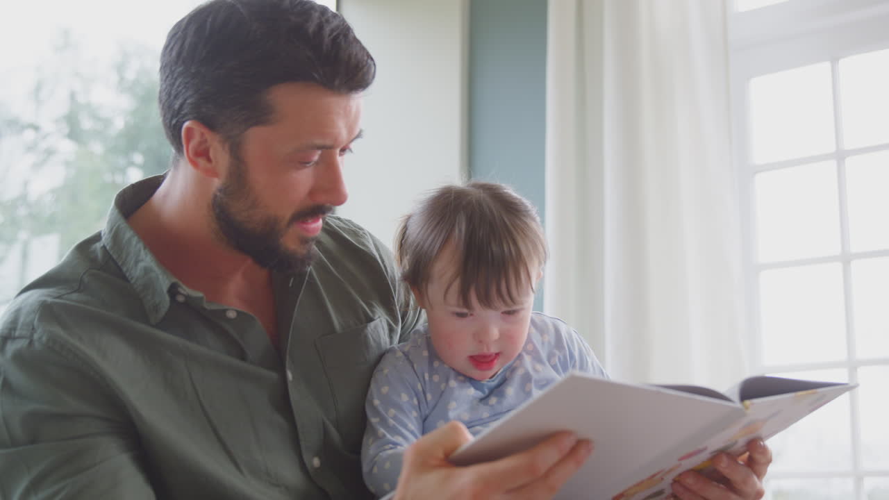 padre con síndrome de down hija leyendo un libro en casa juntos