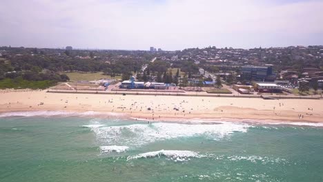 Beautiful-left-side-pan-along-the-coastline-of-eastern-beach-in-Sydney-Maroubra-with-wave-crashing-the-shore