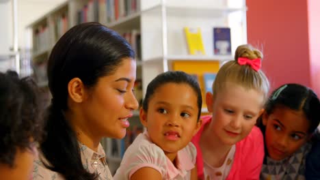 Asian-female-teacher-teaching-schoolkids-in-school-library-4k