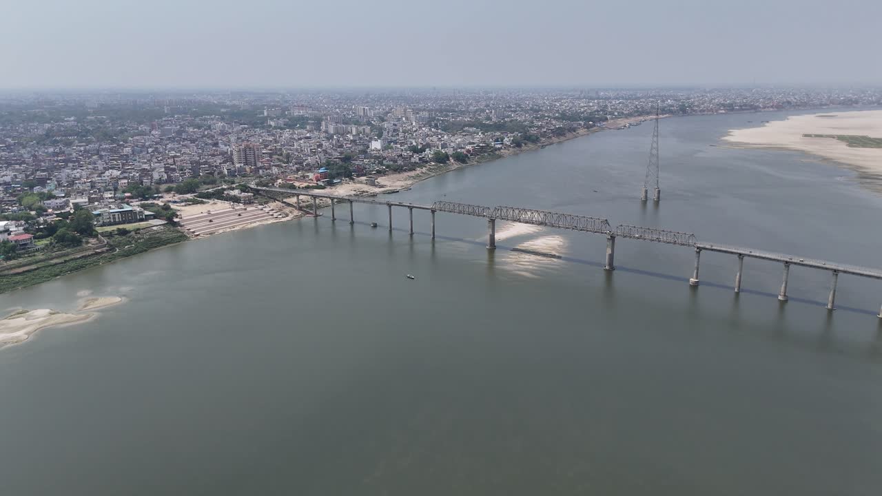 Aerial shot of the Ganges River at sunset, casting a warm glow over the ancient city of Varanasi.