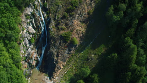 Toma-Panorámica-Aérea-De-Caída-Cinematográfica-De-Una-Pequeña-Cascada-En-Suiza