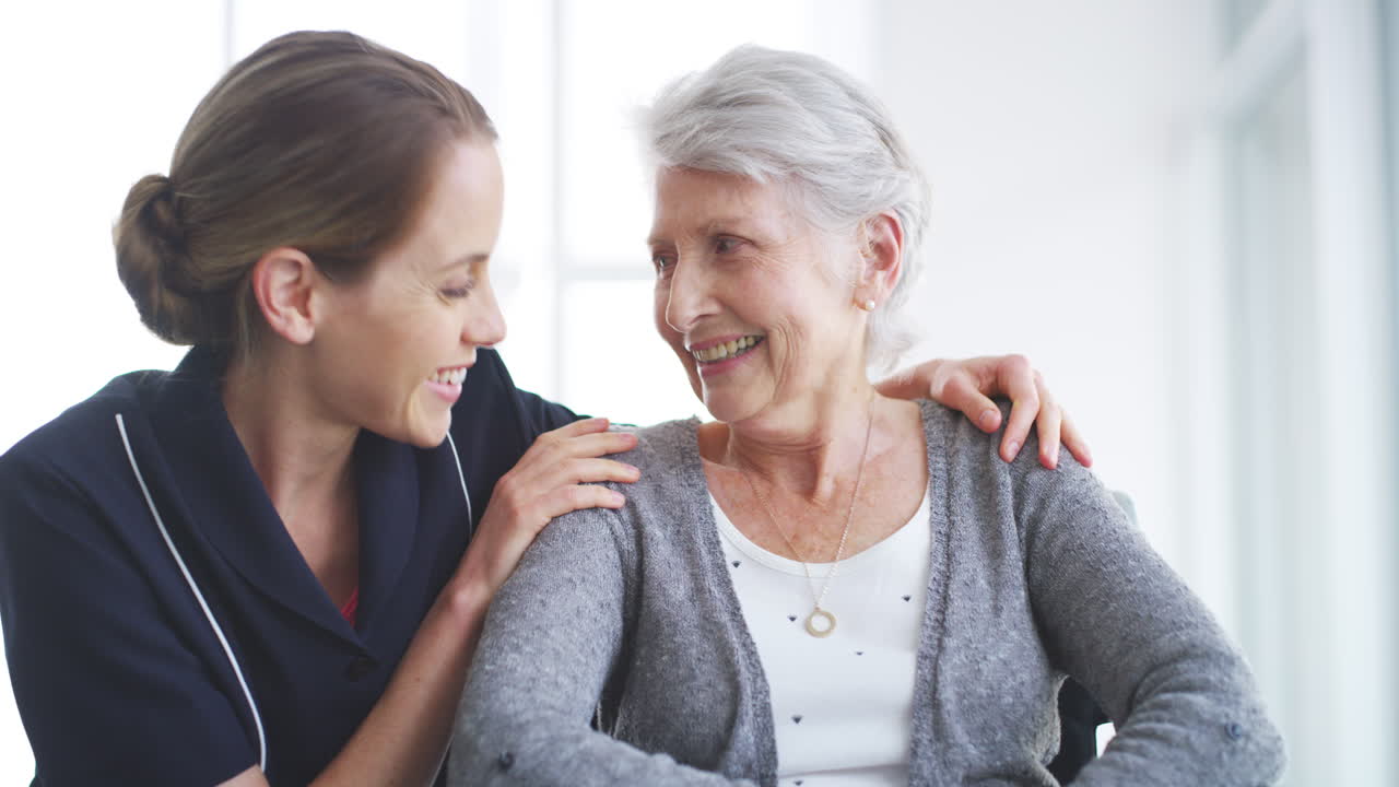 간호사 가  ⁇ 체어 에 앉아 있는 고령 여성 을 밀고 있다
