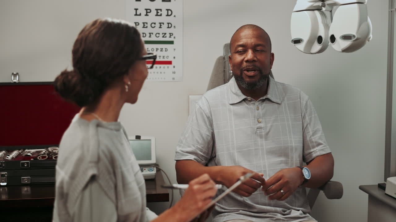 A patient talking to an ophthalmologist during an eye exam