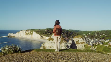 woman overlooking the white cliffs of etretat, france