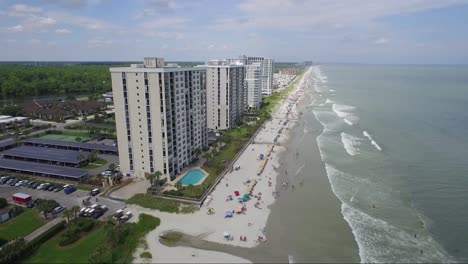 Flying-towards-tall-ocean-front-resorts-near-the-beach-in-summer