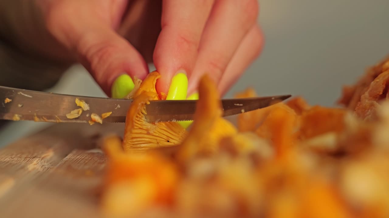 Warm sunset light illuminates knife slicing chanterelles on cutting board scene