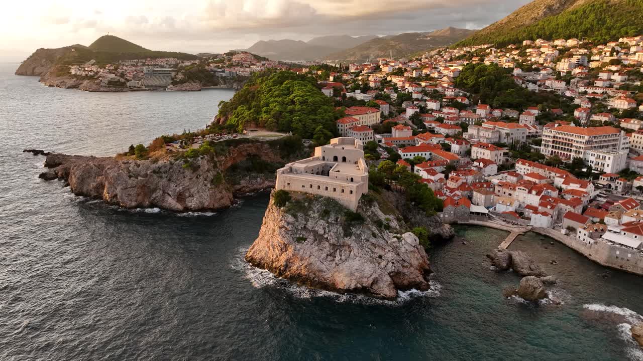 Dubrovnik's historic coast at golden hour, featuring stone buildings, aerial view