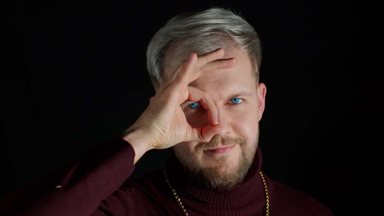 joven alegre y emocionado mirando a la cámara sonriendo encantador mostrando ok ok gesto, diversión, disfrute