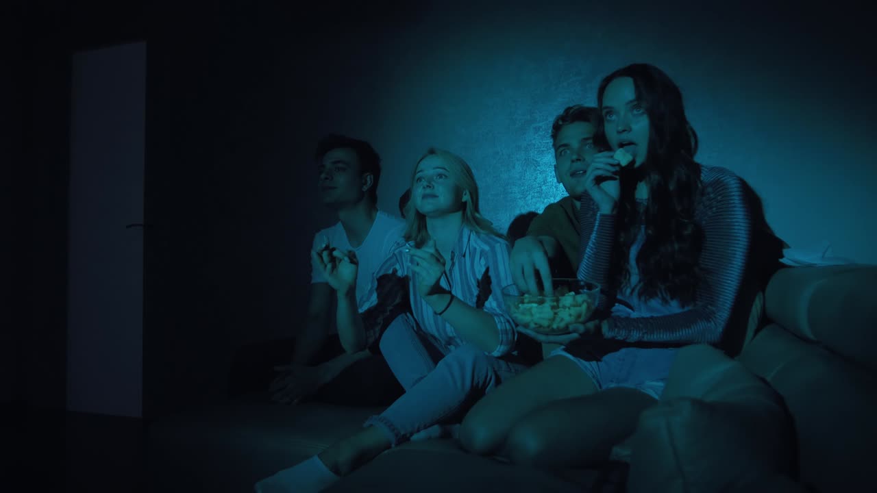Giovani amici che guardano un film in televisione insieme.