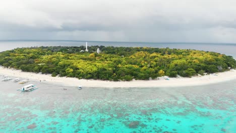 aerial footage of balicasag island in philippines. stunning view on coral reef and circle island. panglao, bohol, white beach, palm trees, boats / 4k drone video