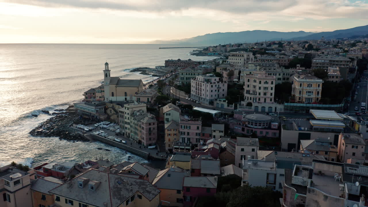 vista del atardecer desde un avión no tripulado sobre boccadasse y los edificios en la costa ligure de génova