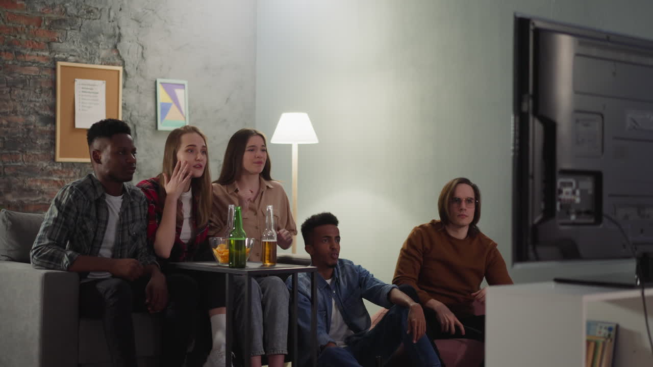 hombre loco hipster lanza el control remoto en el televisor y asusta a los amigos