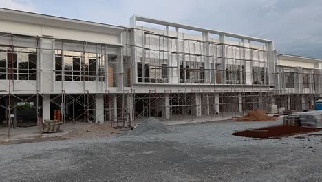 a newly built two-story shop lot in the final stage of construction with modern design, wide facade, and spacious road infrastructure.