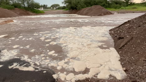 Primer-Plano-De-Espuma-Y-Agua-Marrón-Durante-Una-Inundación-Repentina-En-Arizona,-Condado-De-Pima