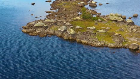 Imágenes-Aéreas-De-Un-Lago-Remoto-En-El-Norte-De-Maine-Volando-Bajo-Sobre-Una-Pequeña-Isla-Rocosa