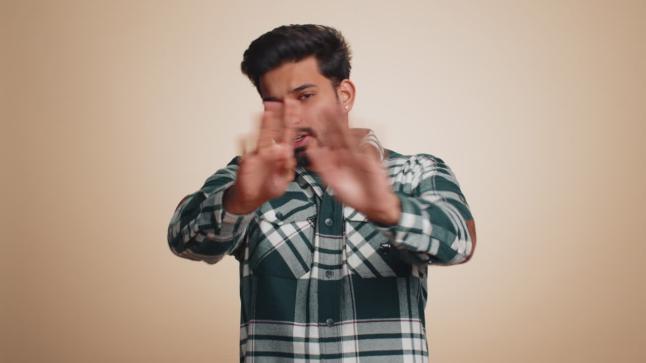 Frightened indian man closing mouth with hands refusing to tell terrible secret unbelievable truth