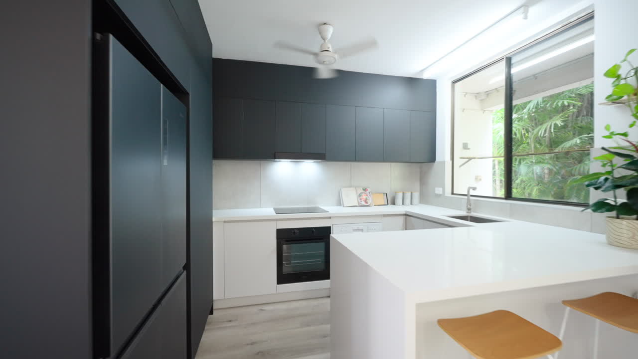 Cozinha de luxo moderna e minimalista com armários pretos e bancadas brancas