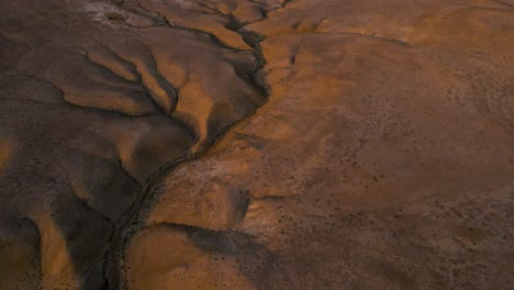 drone shot flying over the desert in the qobustan national park in azerbaijan while panned down