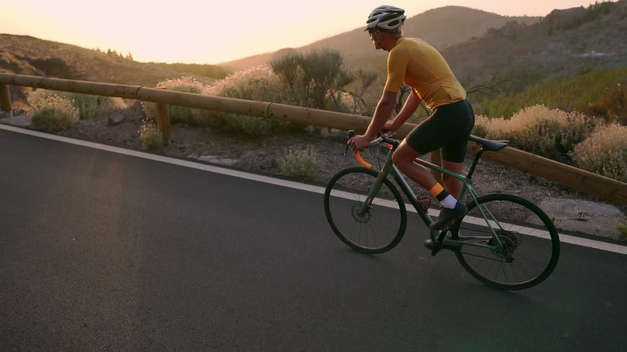 Slow motion captures the athlete on a bicycle traversing a mountain serpentine, basking in the island's beauty, a true embodiment of a healthy lifestyle